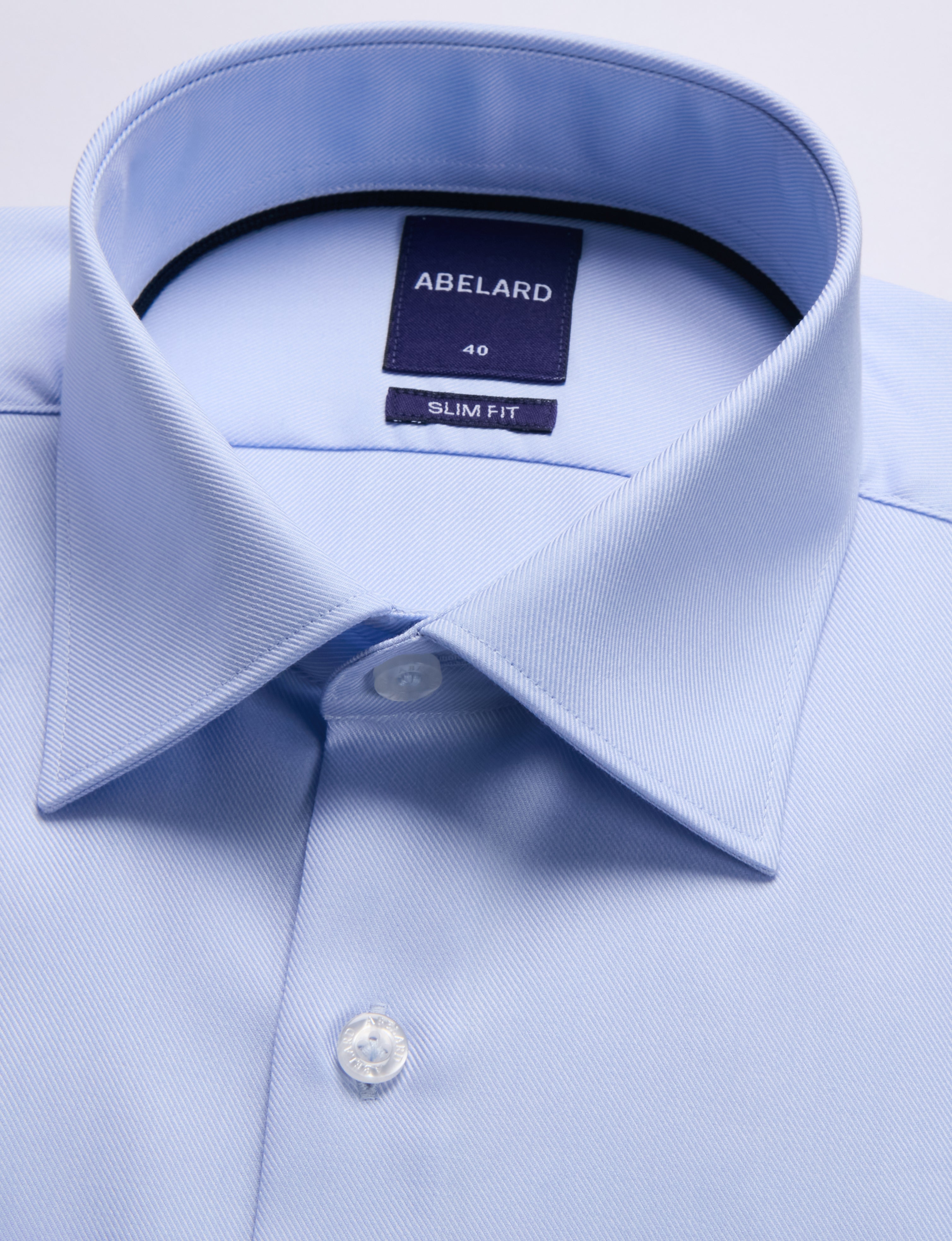 Light blue dress shirt with collar and brand label on a light gray background